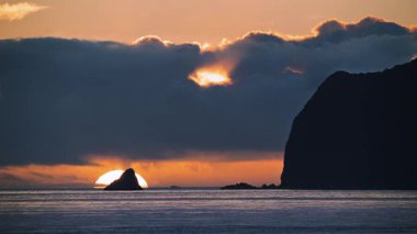 Waishuangxi Beach Keelung Tayvan 'dan çarpıcı bir deniz manzarası. Altın gün doğumu, güzel turuncu tonlarıyla suyu ve gökyüzünü aydınlatır..