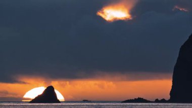 Jiulong Adası siluetinin düş gibi turuncu ve altın rengi gökyüzüne vurduğu Keelung Outer Waishan 'da büyülü gün doğumunu yakalayın. 10 Haziran 2025 'te balıkçı tekneleri ve deniz manzarası ile çekilmiştir..