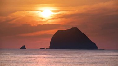 Waishuangxi Beach Keelung Tayvan 'dan nefes kesici bir gündoğumu videosu. Güneş Keelung Adası 'nın üzerine doğar altın turuncu tonlarıyla gizemli ve dramatik bir gökyüzü yaratır..