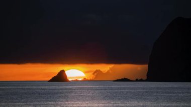 Tayvan, Keelung Waimushan 'da çarpıcı bir yaz gündoğumu. Güneş, turuncu gökyüzü ve sakin denizle Keelung Adası 'nın arkasından yavaşça yükseliyor..