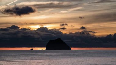 Tayvan, Keelung Waimushan 'da çarpıcı bir yaz gündoğumu. Güneş, hızlı hareket eden kara bulutlar tarafından gizlenir ve sakin denizin üzerinde dramatik bir sahne yaratır..