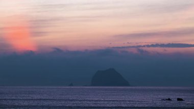 Neon renkli bulutlar ve sakin dalgalarla Keelung Waimushan, Tayvan 'da şafak öncesi sakin gökyüzünün tadını çıkarın. Bu yaz 2025 'te çekilen filmde mavi-turuncu gökyüzü ve canlı renkler yer alıyor..