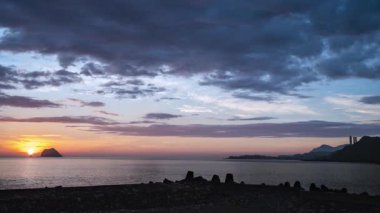 Waimushan Tayvan 'da yaz gündoğumu. Güneş Keelung Adası' nın ardından yükseliyor. Durgun denizin üzerinde turuncu sarı ve mavi gökyüzü..