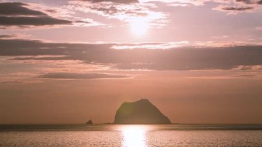 Güneş kara bulutların ardından yükselirken Tayvan 'ın başkenti Keelung Waimushan' da Jilong Adası 'nın siluetine tanık olun. 2025 'te çekilmiş..