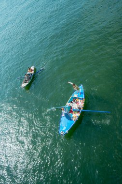 Esna Lock, Mısır - 17 Ocak 2025: Küçük teknelerdeki yerel satıcıların bir yolcu gemisine kürek çekmeleri. Satıcılar yolcu gemisinde turistlere Mısır havlusu satıyorlar..