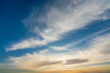 İnce bulutlu canlı ve dramatik bir gökyüzü, güneş batarken parlak maviden sıcak, altın sarısına geçişi sergiliyor. Fotoğraf, Luxor ve Esna yakınlarındaki Nil gezisi sırasında çekildi..