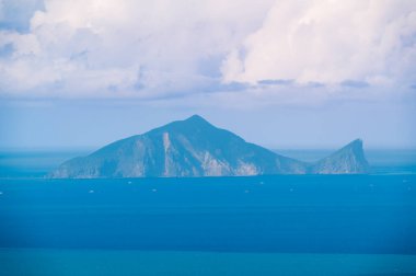 Dongshan, Yilan County, Tayvan 'daki Lanyang Ovası' nın nefes kesici yüksek açılı manzarası mavi denizin karşısındaki görkemli Guishan Adası 'nın sakin bulutlarla kaplı gökyüzünün altında görünmesi..