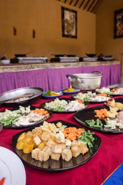Plates of prepared ingredients for a Balinese cooking class, vertical