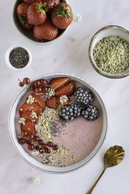 Meyveli, çilekli, böğürtlenli, tohumlu sağlıklı bir meyve suyu kasesi.