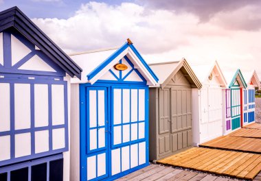 Cayeux sur mer, Somme, Normandiya, Fransa 'da bulutlu ve gökyüzü olan renkli sahil kulübeleri