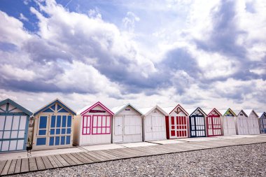 Cayeux sur mer, Somme, Normandiya, Fransa 'da bulutlu ve gökyüzü olan renkli sahil kulübeleri