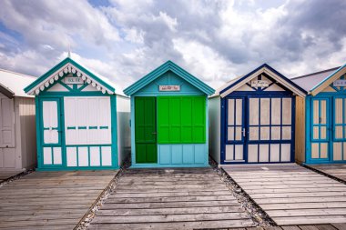 Cayeux sur mer, Somme, Normandiya, Fransa 'da bulutlu ve gökyüzü olan renkli sahil kulübeleri