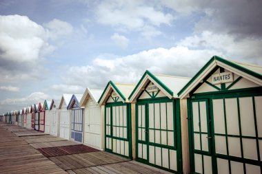 Cayeux sur mer, Somme, Normandiya, Fransa 'da bulutlu ve gökyüzü olan renkli sahil kulübeleri
