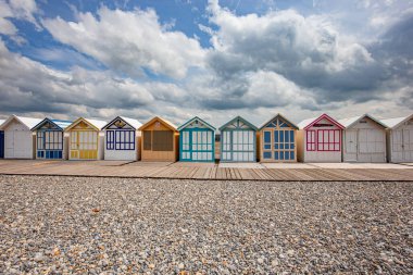 Cayeux sur mer, Somme, Normandiya, Fransa 'da bulutlu ve gökyüzü olan renkli sahil kulübeleri