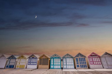 Cayeux sur mer, Somme, Normandiya, Fransa 'da bulutlu ve gökyüzü olan renkli sahil kulübeleri