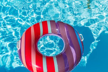 Yazın mavi dalgalar ve güneşli havuzda renkli bir şamandıra.