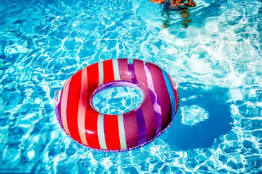 Yazın mavi dalgalar ve güneşli havuzda renkli bir şamandıra.