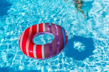 Yazın mavi dalgalar ve güneşli havuzda renkli bir şamandıra.