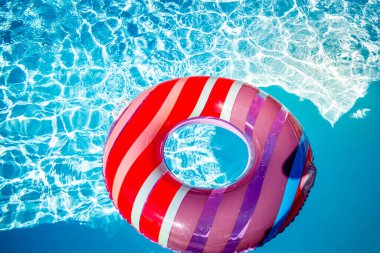 Yazın mavi dalgalar ve güneşli havuzda renkli bir şamandıra.