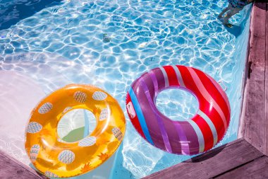 Yazın mavi dalgalar ve güneşli havuzda renkli bir şamandıra.