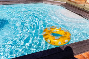 Yazın mavi dalgalar ve güneşli havuzda renkli bir şamandıra.