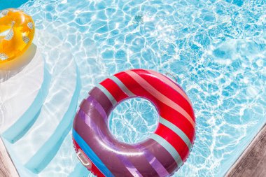 Yazın mavi dalgalar ve güneşli havuzda renkli bir şamandıra.