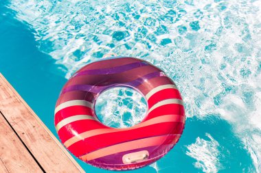 Yazın mavi dalgalar ve güneşli havuzda renkli bir şamandıra.