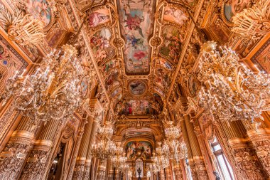PARIS, FRANCE, 14 Mart 2017: 19. yüzyıl Paris Operası, Garnier Sarayı 'ndaki büyük fuayenin iç freskleri ve avizeleri
