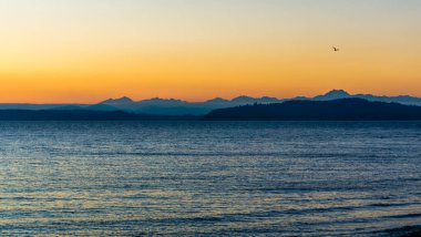 Puget Sound 'un karşısındaki Olumpic Dağları' nın ardında gün batımı.