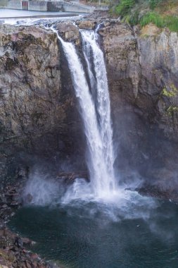 Su Washington 'daki Snoqualmie Falls' un yüzeyinden aşağı akıyor..