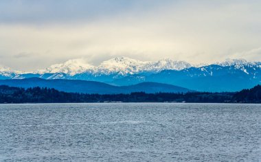 Thick clouds hang over the Olympic Mountains in Washington State.