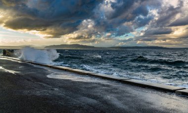 Dalgalar, Batı Seattle, Washington 'daki Alki Sahili' nin deniz duvarına vuruyor..