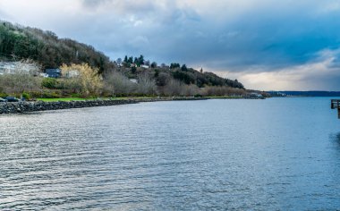 Clouds hang over the shoreline in Ruston, Washington. clipart