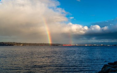 Brilliant rainbow over the water in Ruston, Washington. clipart