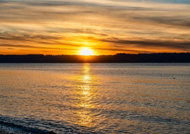 Puget Sound 'da batan güneşin çevresindeki zengin renkler. Fotoğraf Burien, Washington 'daki Seahurst Sahili' nden çekildi..