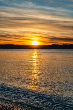Puget Sound 'da batan güneşin çevresindeki zengin renkler. Fotoğraf Burien, Washington 'daki Seahurst Sahili' nden çekildi..