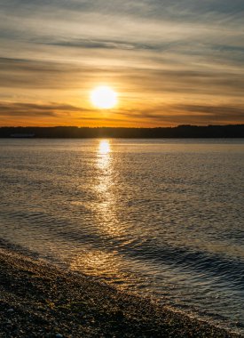 Puget Sound 'da batan güneşin çevresindeki zengin renkler. Fotoğraf Burien, Washington 'daki Seahurst Sahili' nden çekildi..