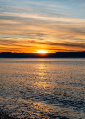 Puget Sound 'da batan güneşin çevresindeki zengin renkler. Fotoğraf Burien, Washington 'daki Seahurst Sahili' nden çekildi..