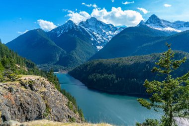 Washington 'daki Kuzey Şelaleleri Otobanı boyunca uzanan dağlar ve su manzarası.