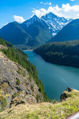 Washington 'daki Kuzey Şelaleleri Otobanı boyunca uzanan dağlar ve su manzarası.