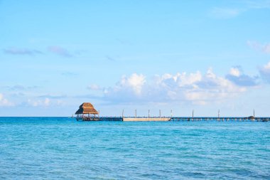 Kuzey sahilindeki kırsal iskele, Isla Mujeres. Meksika Karayipleri 'nin turkuvaz mavisi denizi ve bulutlarla dolu bir gökyüzü. Gün ortası
