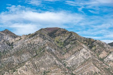 Tremonton, Utah 'ta 15 numaralı otobanda görülen dağların manzarası öğleden sonra bulutlu güzel mavi bir gökyüzü..