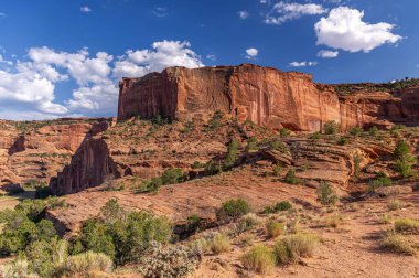 Arizona 'daki Chelly Kanyonu Ulusal Anıtı' nın nefes kesen manzarasını deneyin. Görkemli kızıl kaya kayalıkları ve açık mavi gökyüzü altında geniş bir çöl arazisi..