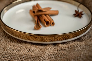 Altın bir tabakta tarçın ve anason kokar, çuval bezinin üstünde. Sert doku ve baharatların bileşimi.