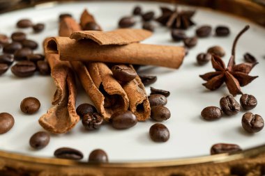 Altın bir tabakta tarçın ve anason, kahve çekirdekleri ve çuval bezi. Sert doku ve baharat kompozisyonu. Kurumuş çiçeklerle. Şekerleme, fırın ve Noel kartlarında kullanılıyor.