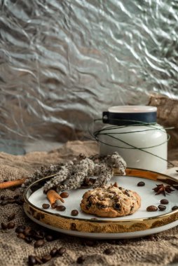 Mumların zarif bir kompozisyonu, baharatların bulunduğu altın kenarlı tabaklar - anason, tarçın ve kahve çekirdekleri. Çuval bezinin arka planına karşı