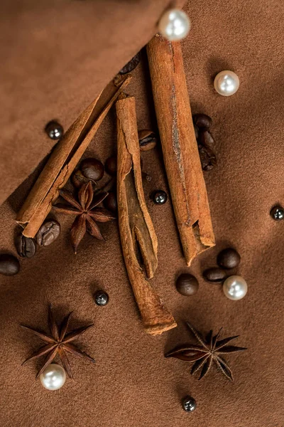 stock image An elegant composition of spices - with anise, cinnamon on a suede brown background with beads and pearls