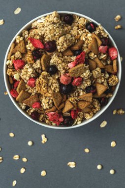 Gri renkli arka planda bir kase müsli, sağlıklı yemek, sağlıklı kahvaltı.