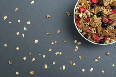 Gri renkli arka planda bir kase müsli, sağlıklı yemek, sağlıklı kahvaltı.