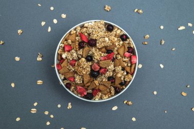 Gri renkli arka planda bir kase müsli, sağlıklı yemek, sağlıklı kahvaltı.